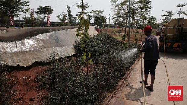 Petugas menyiram taman dan rumput di sekitar arena bermain RPTRA Kalijodo.