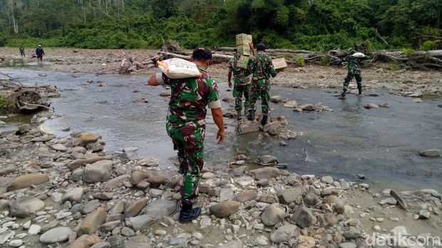 Anggota TNI menyalurkan bantuan untuk suku Mausu Ane yang ada di pedalaman Maluku Tengah.