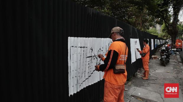Para petugas PPSU atau Pasukan Oranye melukis mural Asian Games 2018 di pinggir jalan Kemang Utara, Jakarta, 25 Juli.