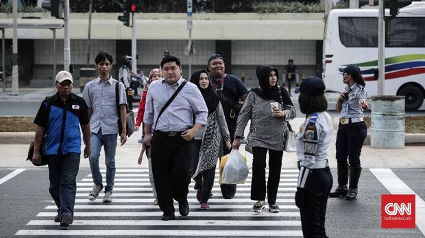 Pejalan kaki memanfaatkan pelican crossing di Kawasan Bundaran HI, Jakarta, Senin, 30 Juli 2018. Jembatan penyeberangan orang di kawasan Bundara Hotel Indonesia, Jakarta Pusat hari ini ditutup sehingga tak bisa dipakai lagi. Sebagai gantinya, pejalan kaki bisa menggunakan pelican crossing yang sudah dibuat sebagai tempat penyeberangan sementara. CNNIndonesia/Safir Makki