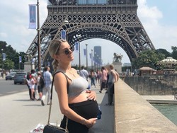 Melanie berpose di depan Menara Eiffel saat perutnya makin membesar. Martial harus meninggalkan kamp latihan pramusim di Amerika Serikat hanya untuk menemani Melanie lahiran akhir kemarin. (Instagram @melaniedacruzzoff)
