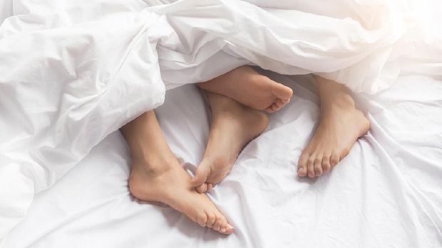 Young couple man and woman intimate relationship on bed feet