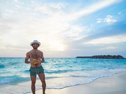 Mohamed Salah tampak memegang kelapa yang diminumnya sambil menikmati hamparan pasir dan deburan ombak. (Instagram @MoSalah11)