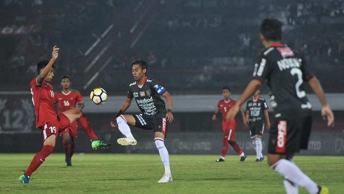 Pesepak bola Timnas U-23 Hanif (kiri) berebut bola dengan pesepak bola Bali United Fadil Sausu (ketiga kiri) dalam laga uji coba jelang Asian Games 2018 di Stadion I Wayan Dipta, Gianyar, Bali, Selasa (31/7). ANTARA FOTO/Nyoman Budhiana/wsj/18.