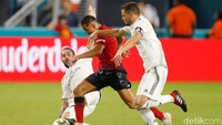 Alexis Sanchez berusaha melewati pengawalan ketat dua pemain Madrid. Dalam pertandinan ini, Alexis Sanchez membuka keunggulan untuk MU di menit ke-18. Reuters/Andrew Innerarity.