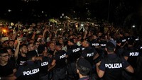 Anggota kepolisian membuat barikade agar fans Milan tidak terus mendekat ke Higuain (REUTERS/Daniele Mascolo)