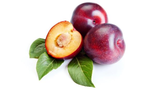 Three ripe plums on white background