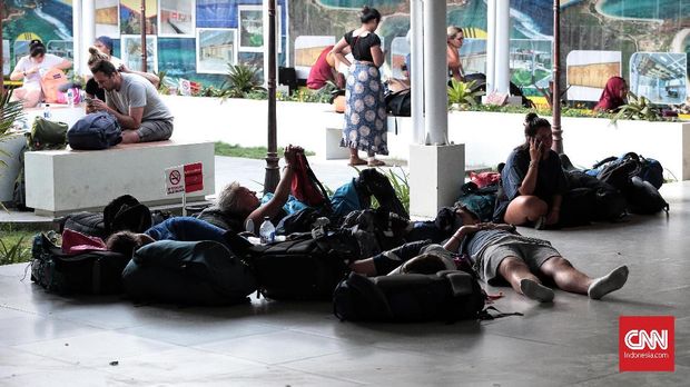 Turis asing tergeletak di Bandara Internasional Lombok seusai proses evakuasi.