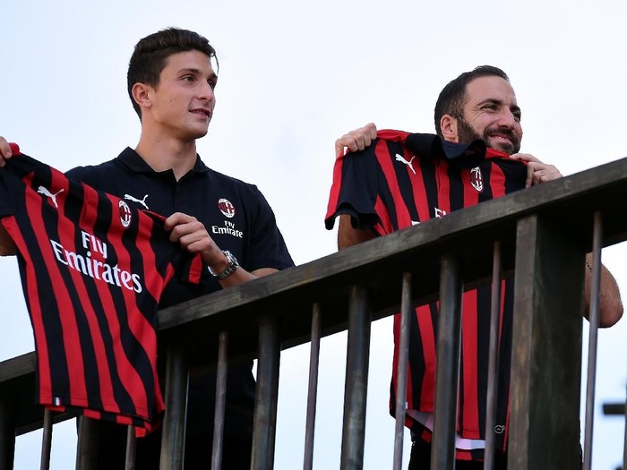 AC Milan striker Gonzalo Higuain and defender Mattia Caldara show the team jersey to supporters in downtown Milan, Italy, August 3, 2018.  REUTERS/Daniele Mascolo