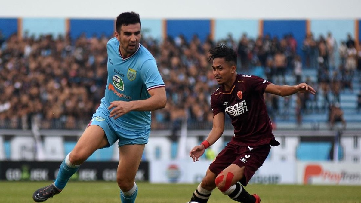 Pemain Persela Lamongan Ahmet Atayev (kiri) berusaha melewati hadangan pesepakbola PSM Makassar Reva Adi Utama (kanan) dalam laga lanjutan Liga 1 di Stadion Surajaya, Lamongan, Jawa Timur, Jumat (10/8). (Risyal Hidayat/Antara)