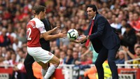 Agar permainan bisa buru-buru dilanjutkan, dan Arsenal kembali bisa berusaha menyerang, Emery tampak membantu Stephan Lichtsteiner mengambil bola. (Foto: Shaun Botterill/Getty Images)