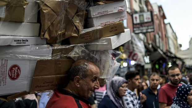 Krisis Ekonomi Turki A man carries empty cardboard boxes near the Grand Bazaar in central Sultanahmet district of Istanbul, on August 11, 2018. / AFP PHOTO / Yasin AKGUL