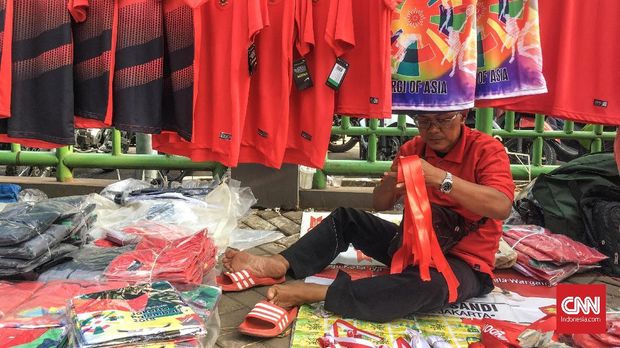 Para pelapak kecil memanfaatkan tempat-tempat umum untuk menjajakan dagangan mereka selama laga Timnas Indonesia bertanding di Asiang Games 2018. (