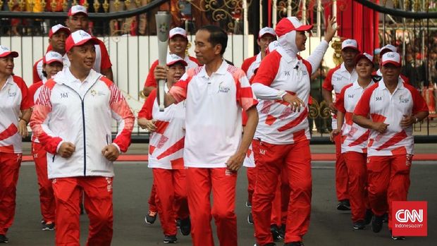 Presiden Jokowi tersenyum kepada Menpora Imam Nahrawi saat mengetahui api obor Asian Games 2018 sempat padam. (