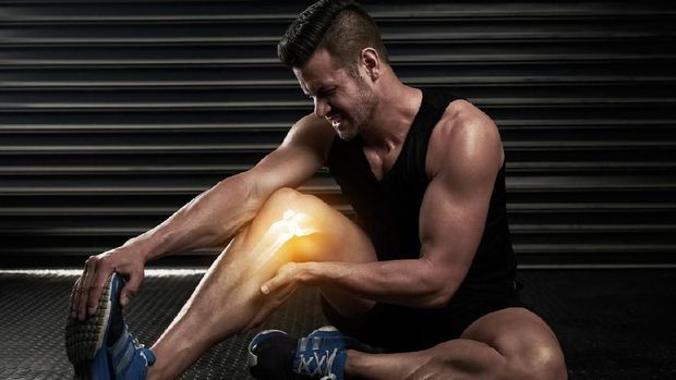 Studio shot of an athletic young man warming up before a workout