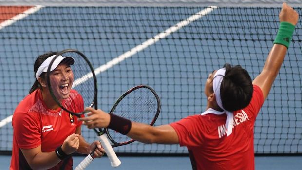 Ekspresi petenis ganda campuran Indonesia Christopher Rungkat (kanan) dan Aldila Sutjiadi seusai mengalahkan petenis Jepang Erina Hayashi dan Kaito Eusugi pada semifinal tenis ganda campuran Asian Games 2018 di Jakabaring Sport City, Palembang, Sumatera Selatan, Jumat (24/8). ANTARA FOTO/INASGOC/Wahyu Putro A/nym/18