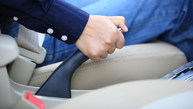 Woman hand pull hand brake of a car