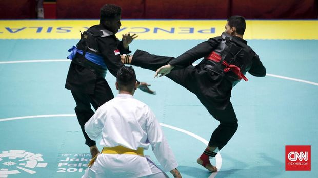 Aji Bangkit pamungkas (merah) meraih medali emas di kelas I putra cabor pencak silat.