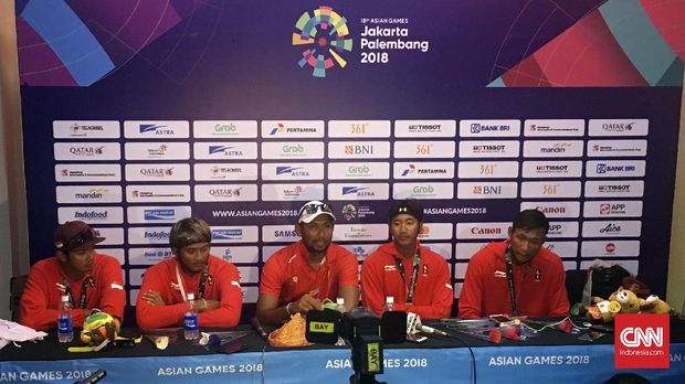 Koko Prasetyo (tengah) diapit dua tim voli pantai putra Indonesia yang berlaga pada Asian Games 2018.