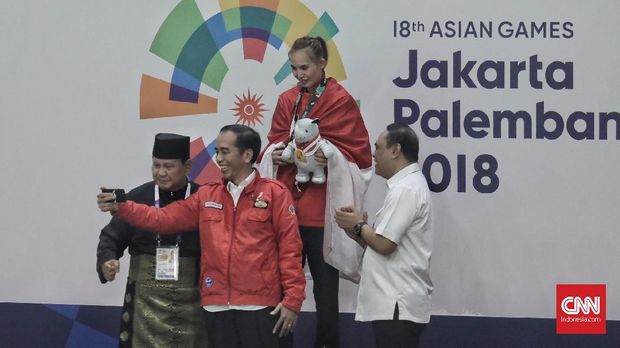 Jokowi dan Prabowo Subianto saat menyerahkan medali emas silat Asian Games 2018.