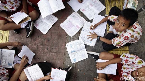 Patut Dicontoh! Siswa SD Ini Menunggu Bus Sambil Belajar