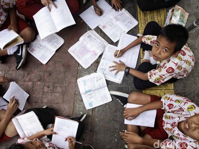 Patut Dicontoh! Siswa SD Ini Menunggu Bus Sambil Belajar