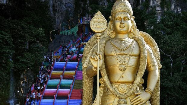 Visitors walk up the newly-painted 272-steps staircase leading to Malaysia's Batu Caves Hindu temple in Kuala Lumpur on August 30, 2018. / AFP PHOTO / Manan VATSYAYANA