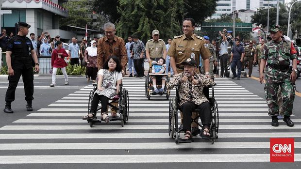 Gubernur DKI Jakarta Anies Baswedan mendorong penyandang disabilitas menyeberang menggunakan pelican crossing di kawasan Bank Indonesia, Jakarta, Selasa (4/9).
