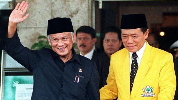 Indonesian President B.J. Habibie (L) waves to journalists as current chairman of the ruling Golkar party Harmoko (R) escorts him to his car 09 July in Jakarta after they attended the opening of Indonesia's ruling Golkar Party extraordinary congress as it efforts to redifine itself in the post-Suharto era and chose a new leadership. The session was attended by more than 1000 of the party's members and held at the Indonesia Hotel. / AFP PHOTO / KEMAL JUFRI