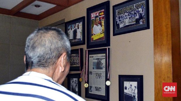 Benny Dolo menatap sejumlah foto semasa aktif sebagai pemain dan pelatih.