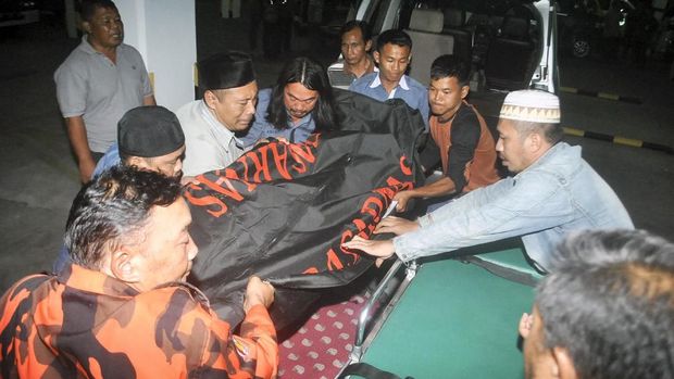 Petugas bersama anggota keluarga memindahkan jenazah korban kecelakaan di Cikidang, Sukabumi, di Rumah Duka Sinar Kasih, Bogor, Jawa Barat, Minggu (9/9).