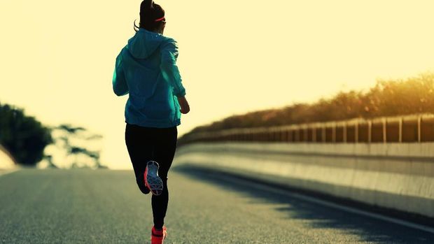 young fitness woman runner running on sunrise road