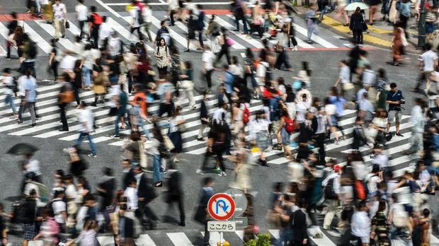 This photo taken on September 15, 2017 shows people walking across a zebra crossing at an intersection in Tokyo.  / AFP PHOTO / Kazuhiro NOGI
