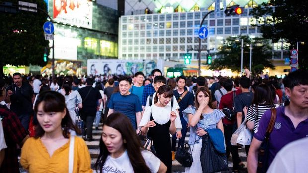 This photo taken on June 30, 2018 shows people crossing the street in Shibuya in Tokyo. / AFP PHOTO / Martin BUREAU