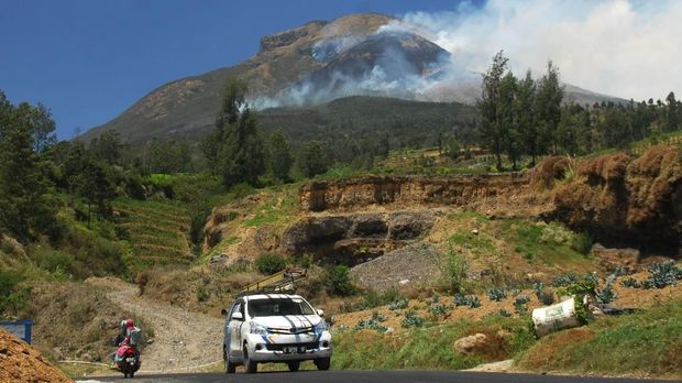 Asap mengepul dari kebakaran hutan gunung Sindoro difoto dari Desa Sigedang, Kejajar, Wonosobo, Tengah, Sabtu (8/9). Kebakaran sejak Jumat (7/9) siang tersebut terjadi di lahan hutan dan ilalang yang  berada pada petak 7B area Perhutani KPH Kedu Utara, Canggal, Candiroto, Temanggung dan masih dalam proses pemadaman oleh Perhutani, BPBD dan masyarakat. ANTARA FOTO/Anis Efizudin/foc/18.