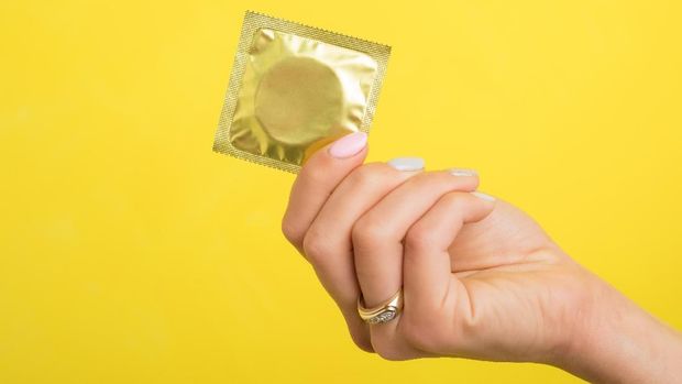 Ilustrasi Kondom Woman holding a condom