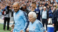 Para pemain Manchester City masuk ke lapangan didampingi maskot mereka yang berusia 102 tahun, Vera Cohen. Cohen merupakan suporter setia City sejak 1930 silam. City yang menjamu Fulham di laga ini menang telak 3-0. (Foto: Phil Noble/REUTERS)