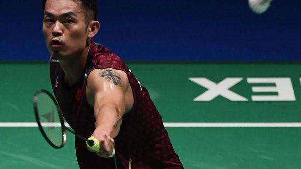 China's Lin Dan hits a return towards Japan's Kento Momota during their men's singles quarter-final match at the Japan Open badminton championships in Tokyo on September 14, 2018. / AFP PHOTO / Toshifumi KITAMURA