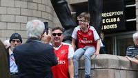 Suporter Arsenal berfoto di patung ikon Newcastle United, Sir Bobby Robson, di laga tandang ke St. James Park. (Foto: Alex Livesey/Getty Images)