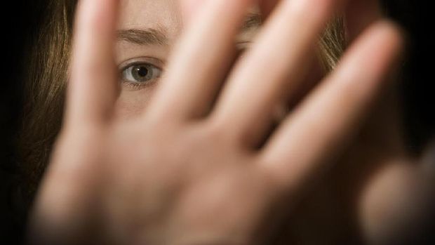 A woman's hands in front of her face.