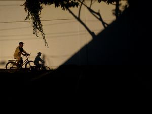 bayangan sepeda dengan pengendaranya dikala sore