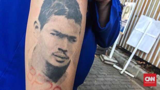 Salah seorang Jakmania yang melukiskan tato wajah Bepe di lengannya. (