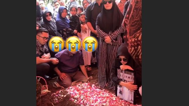Syahrini di depan pusara kakaknya.