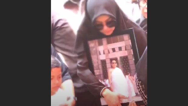 Syahrini di depan pusara kakaknya.