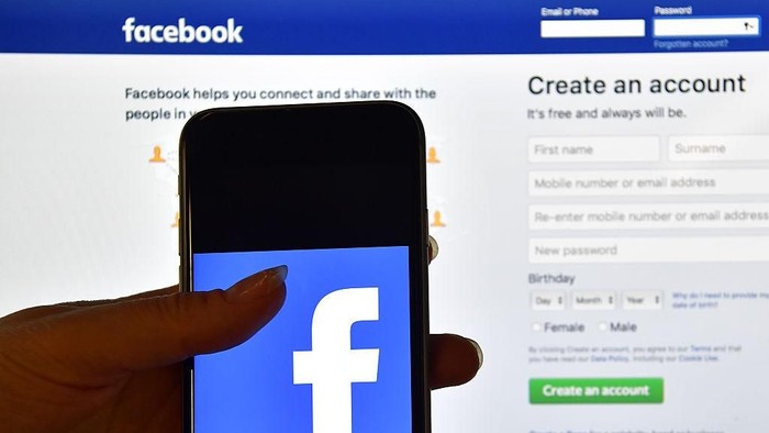 LONDON, ENGLAND - AUGUST 03: A person holds an iPhone displaying the Facebook app logo in front of a computer screen showing the facebook login page on August 3, 2016 in London, England.  (Photo by Carl Court/Getty Images)