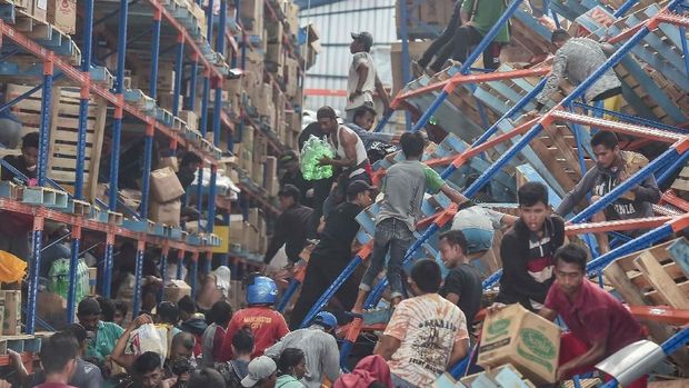 Warga korban gempa mengambil berbagai keperluan logistik sebuauh toko, di Mamboro, Palu Utara, Sulawesi Tengah, Senin (1/10).