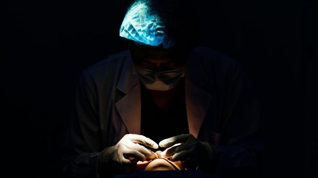 surgeon doing medical cosmetic surgery  in operating room