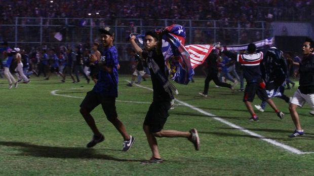 Suporter Arema memasuki lapangan saat tim kesayangannya mengalahkan Persebaya 1-0.