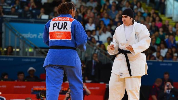 Pejudo Arab Saudi Wojdan Shaherkani (putih) memodifikasi jilbabnya di Olimpiade 2012.