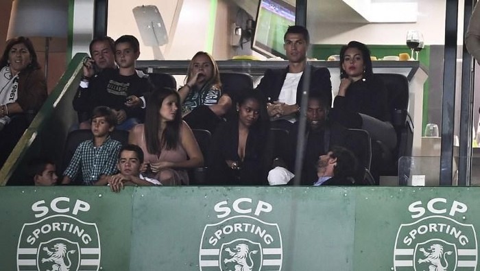 Real Madrid and Portugal's forward Cristiano Ronaldo (2R) and his girlfriend Georgina Rodriguez (R) attend the Portuguese league football match Sporting CP vs CD Tondela at the Jose Alvalade stadium in Lisbon on September 16, 2017. (Photo by PATRICIA DE MELO MOREIRA / AFP)